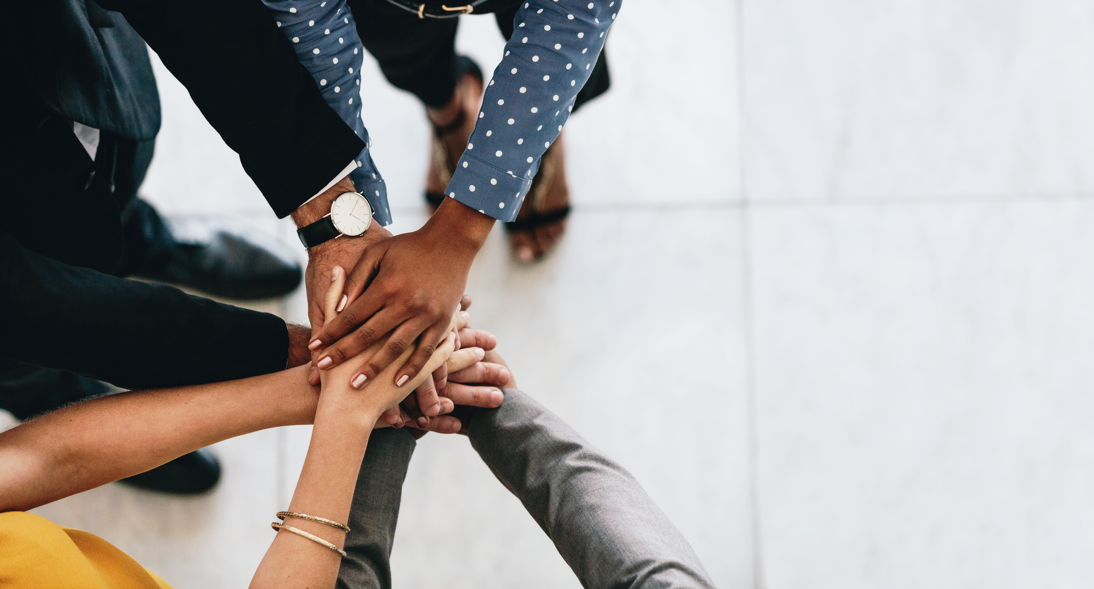 A team bringing their hands together in a show of unity